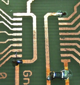 Soldering SMD by hand: applying tin to the opposite corner pads of a chip.