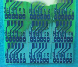 A circuit board with 12 individual adapter boards taking a bath in sodium persulfate solution.